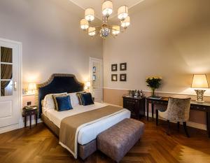 佛罗伦萨帕拉佐罗塞利切克尼酒店的一间卧室配有一张大床和一个吊灯。