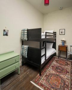 巴利卡斯尔Magherintemple Lodge的一间卧室配有双层床和地毯。