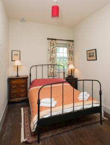 巴利卡斯尔Magherintemple Lodge的一间卧室设有床、两个床头柜和窗户