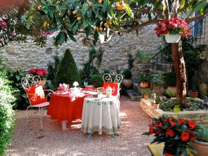 马莱莫尔拉麦迅派恩特雷普罗旺斯酒店的花园里种满鲜花,配有桌椅