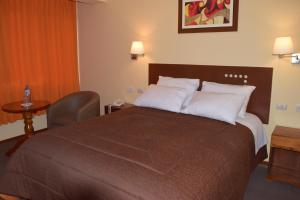 HuancavelicaIllariy Hotel的酒店客房配有一张带白色枕头的大床