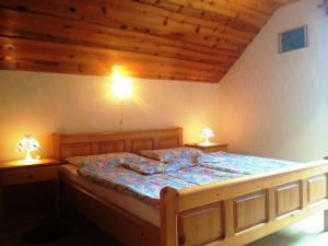 索尔察瓦Farm Stay Juvanija的一间卧室配有一张木床,两边都配有两盏灯