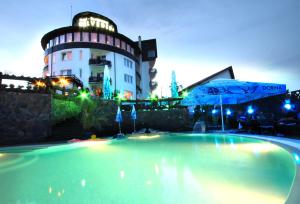 布拉索夫贝尔福德雷尔酒店的一座游泳池,在晚上在建筑物前