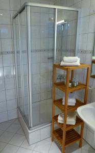 塞恩德伯祖姆兰德宫酒店的带淋浴的浴室以及带毛巾的木制架子。