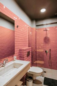 约阿尼纳羽衣甘蓝精品旅馆的一间带红砖墙、浴缸和卫生间的浴室