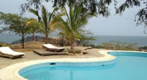 曼克拉海洋美景度假屋的一座带两把躺椅和树木的大型游泳池