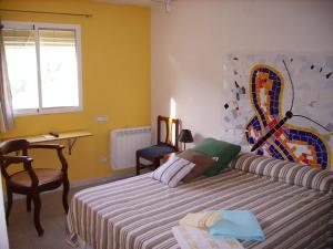 PaúlsCa les Barberes的一间卧室配有一张床、一张书桌和一个窗户。