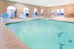 杜马Invision Inn - Dumas的一座配有桌椅的酒店游泳池