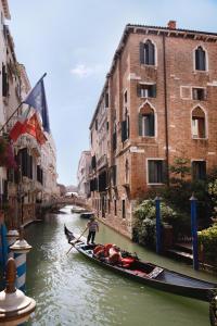 威尼斯多纳宫酒店的一个人在运河上划上一条船