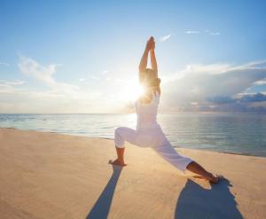 努沙杜瓦丹绒纱丽旅馆的一名在海滩上做瑜伽姿势的女人