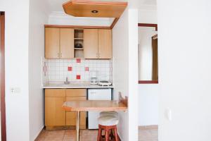 锡德贝格安维尔公寓式酒店的一间带木制橱柜和木桌的小厨房