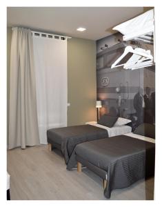AssoroB&B Stazione Dittaino的酒店客房设有两张床和窗户。