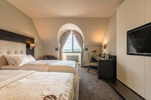布尔诺胜利酒店的酒店客房设有两张床和一台平面电视。