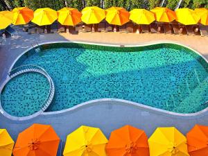 华欣宜必思 华欣  的游泳池的顶部景色,游泳池配有五颜六色的遮阳伞