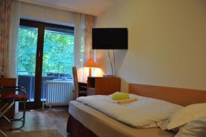 比勒费尔德瓦尔德比勒费尔德旅馆的一间卧室配有一张床、一张书桌和一个窗户。