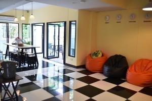 曼谷隐逸曼谷旅舍的客房铺有带椅子和桌子的 ⁇ 格地板。