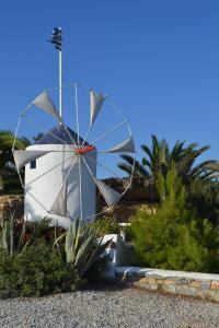 考弗尼西亚Anemomylos Houses的棕榈树屋前的风车
