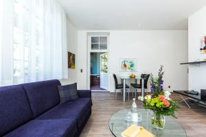 博尔滕哈根Villa Höger的客厅配有蓝色的沙发和玻璃桌