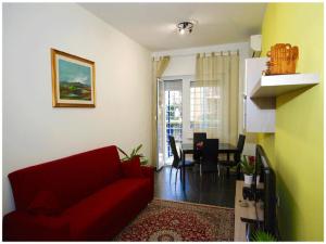 罗马罗马公寓的一间带红色沙发的客厅和一间用餐室