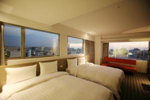 嘉义市嘉义乐客商务旅馆的配有大窗户的酒店客房内的两张床