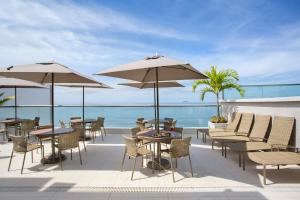里约热内卢阿特兰蒂寇海滩酒店的一个带桌子和遮阳伞的庭院和大海