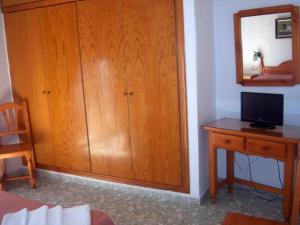 卡沃内拉斯费利佩酒店的客房设有木制橱柜和带电视的书桌。