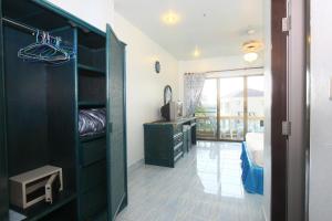 芭东海滩Patong Sunbeach Mansion的客房设有带梳妆台和书桌的卧室。