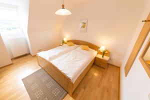 Hartmannsdorf佐勒农场假期酒店的一间铺有木地板的小卧室,配有一张床