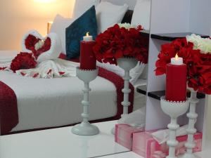 MawāliḩAl Mawaleh Furnished Flats & Rooms的一间设有一张红色鲜花和蜡烛的床的房间