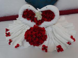 MawāliḩAl Mawaleh Furnished Flats & Rooms的两只天鹅用红玫瑰制成的床