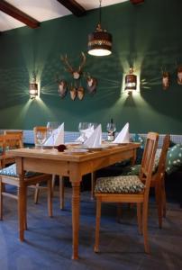 施罗本豪森施罗本豪森布劳农家老城酒店的一张带椅子的木桌和绿色的墙壁