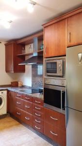 阿拉色那Casa Rural La Era 2 - Adults Only的厨房配有木制橱柜和不锈钢冰箱。