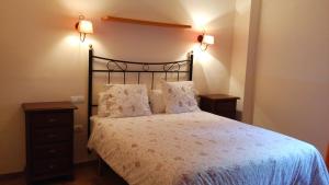 阿拉色那Casa Rural La Era 2 - Adults Only的一间卧室配有一张带2个床头柜和2盏灯的床。