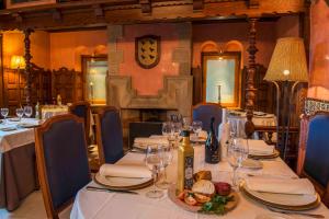 拉瓜迪亚科亚多城堡酒店的用餐室配有带酒杯的桌子