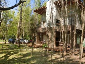查斯科穆斯Complejo Aires del Bosque的树林里的房子,前面有树木