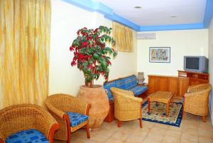 马拉希亚斯Melistas Rooms的客厅配有桌椅和盆栽植物