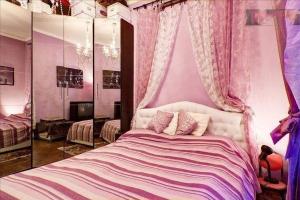 米兰浪漫与艺术公寓 的一间卧室配有一张带粉红色墙壁和窗帘的床
