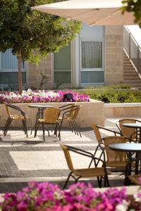 耶路撒冷Ein Kerem Hotel的花朵庭院里的一组桌椅