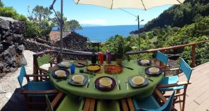 Baía de CanasAdega dos Terceira的阳台顶部带食物的绿桌