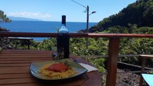 Baía de CanasAdega dos Terceira的桌上的一盘意大利面和一瓶葡萄酒