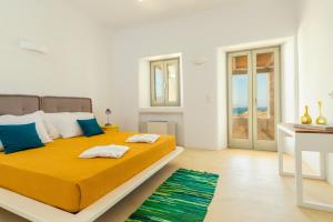 法蒂亚Villa Ftelia Boheme的一间卧室配有一张大床,配有黄色的床单和蓝色的枕头。