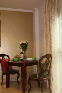 大加那利岛拉斯帕尔马斯Tiffany's Apartment的餐桌,带两把椅子和花瓶