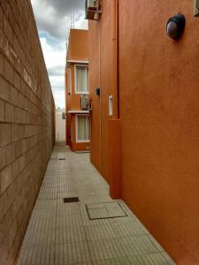 Las PerdicesNec Apart Hotel的一座建筑中空无一人的走廊,有橙色的墙壁