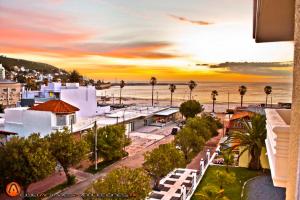 皮里亚波利斯Hotel Esmeralda的享有棕榈树和大海的城市美景。
