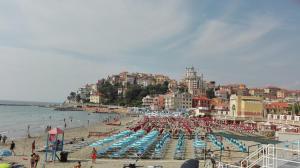 因佩里亚Case Vacanze Borgo Marina IMPERIA的海滩上摆放着一堆椅子和遮阳伞