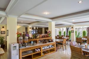 日惹杜达花园酒店的一间带桌椅和花瓶柜台的餐厅