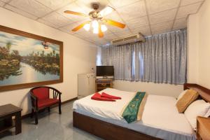 南芭堤雅安可尔酒店的一间卧室配有一张床和吊扇