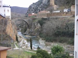 阿尔内迪略Casa Rural Peñalba的一座河上的桥梁,山底下