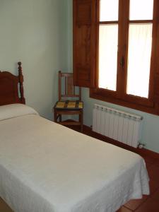阿尔内迪略Casa Rural Peñalba的卧室配有白色的床和2扇窗户。