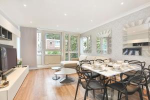 伦敦Sach's 2 Bedrooms Apartment - No lift的厨房以及带桌椅的起居室。